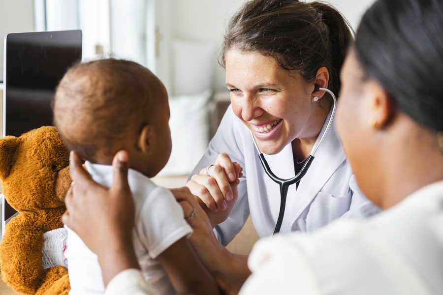 Group Health Insurance - Family Doctor Helping Baby with Teddy Bear