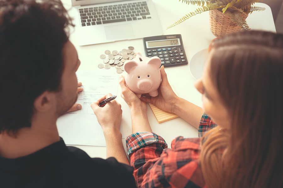 Insurance Quote - Young Couple Sitting At Desk Working On Their Finances At Home